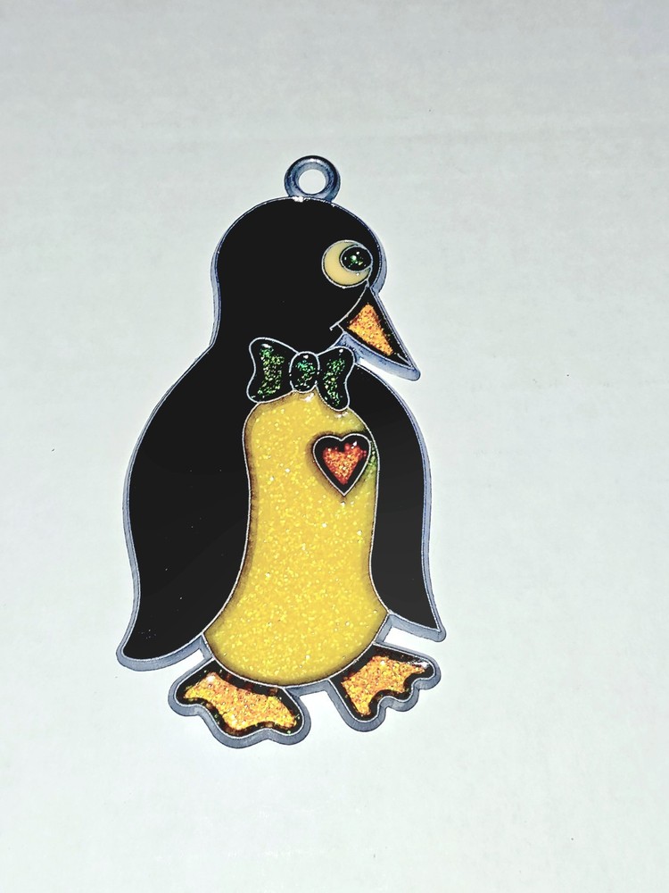 1980s vintage penguin suncatcher features a yellow glitter belly and a red heart